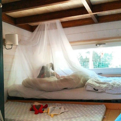 Chambre de bébé en Tiny House, lit montessori et moustiquaire. 