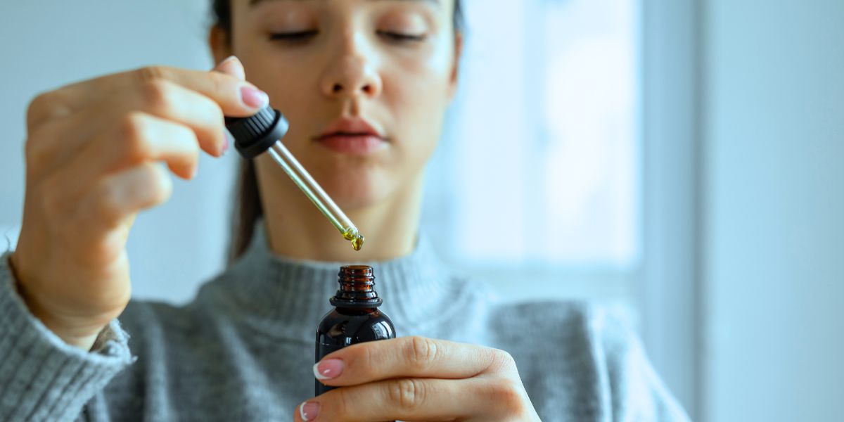 Femme dose son CBD avec une pipette